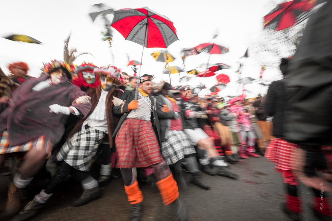 La première ligne du carnaval tenant leur berguenard et donnant la sensation de s'écrouler dans un flou artistique.