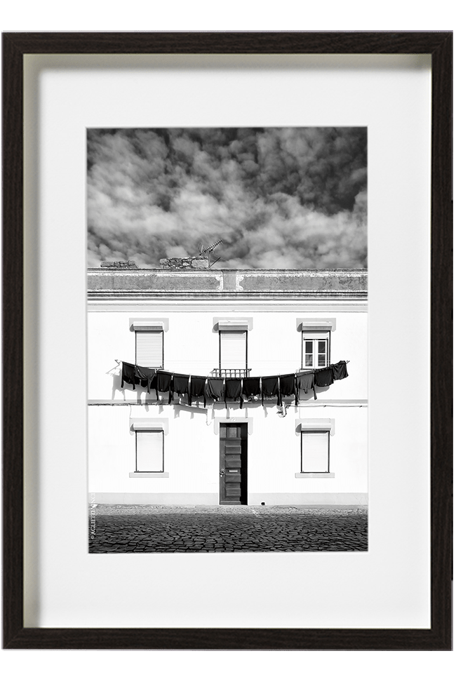 A Evora, au Portugal, du linge est accroché sur le devant d'une maison blanche et forme une longue guirlande de pulls au dessus de la porte. d'entrée.