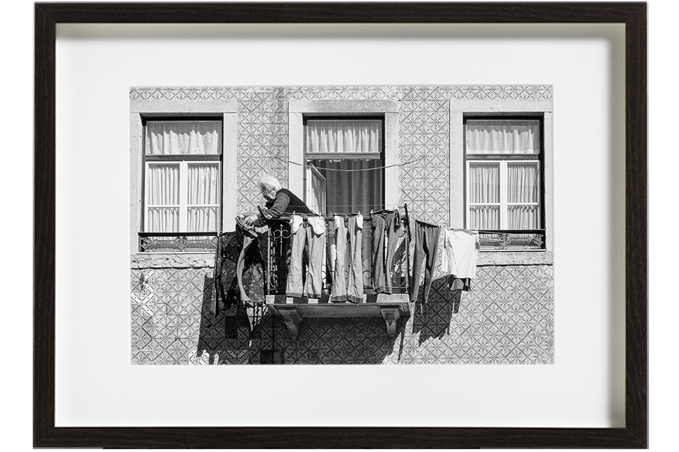 A Lisbonne, au Portugal, dans le quartier de Graca, une vieille dame aux cheveux blancs accroche son linge tout autour de son petit balcon.