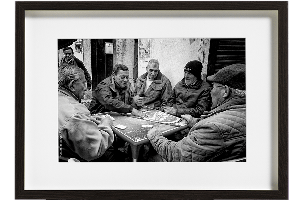 A Lisbonne au Portugal, dans le quartier d'Alfama, 5 hommes sont assis autour d'une table et jouent aux cartes. Ils partagent une partie de Sueca.