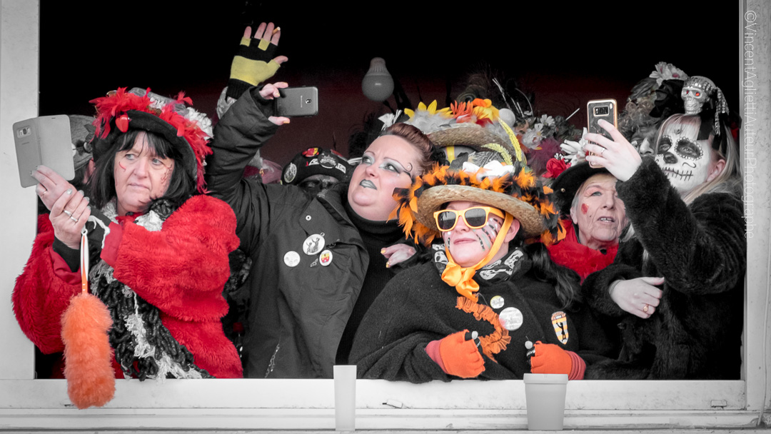 Carnaval de Dunkerque .Un groupe de femmes, à la fenêtre d'un immeuble, immortalise à l'aide de leur portable la bande de Malo chantant les refrains bien connus également de ces carnavaleuses.