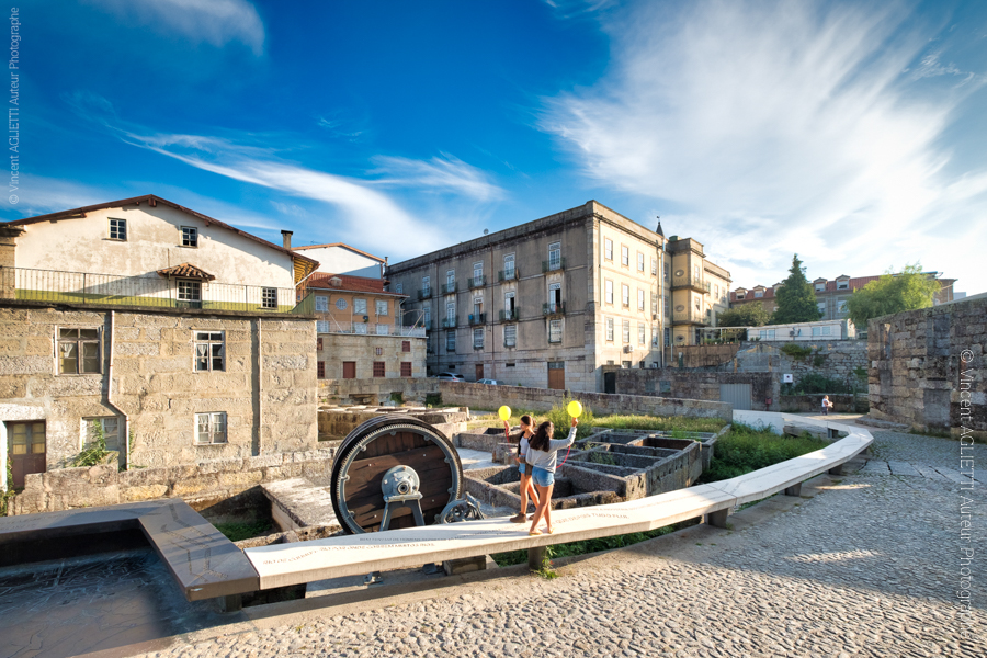 Deux jeunes filles marche sur un muret le long d'un lavoir à Guimaraes au Portugal. Mise en scène par Vincenzo Cirillo un ballon jaune à la main elles sont photographiées par Vincent Aglietti.