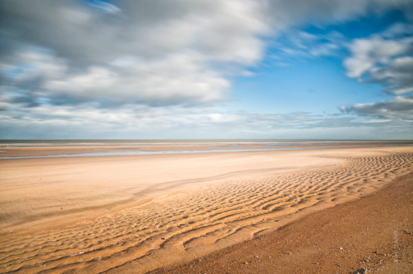 Beach. Des étendues de sable à perte de vue avec un ciel tourmenté, c'est typiquement la Mer du Nord.