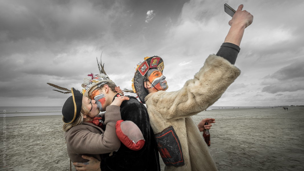 Selfie. Un couple de Carnavaleux sur la plage de Malo les Bains s'embrassant. Un homme photographiant en mode selfie.