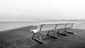 Face à la Mer.Un banc vide face a la mer du nord, la plage est vide et le ciel se couvre.