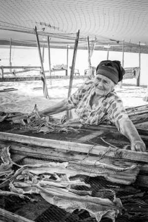 Adelina prépare tous les matin le séchage des poissons en installant son étale sur la plage de Nazaré.