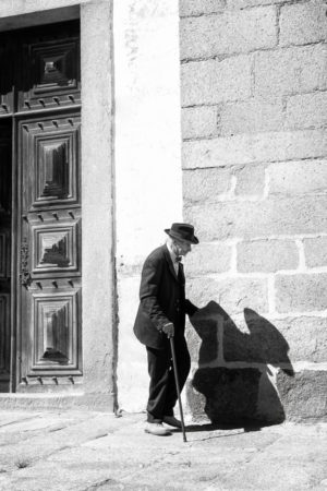 A Petits Pas. Une canne et une ombre accompagnent ce vieux passant d'Evora.