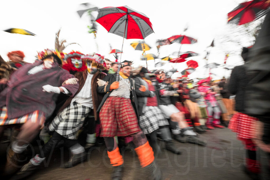 Personnages déguisés pendant le carnaval de Dunkerque effectuant une première ligne. la photo fige ces personnages dans un flou artistique.