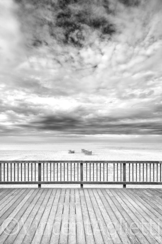 Plage de Knokke-le-Zoute en automne sous un ciel nuageux en noir et blanc