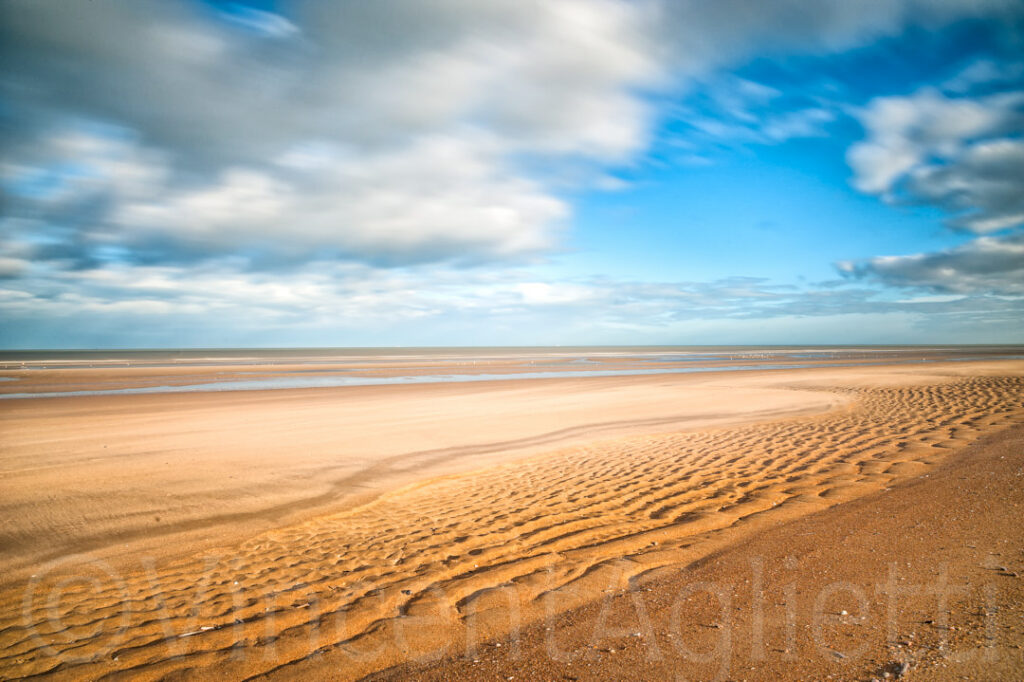 Longue plage de la mer du Nord entre Ostende et Knokke-le-Zoute sous un ciel nuageux