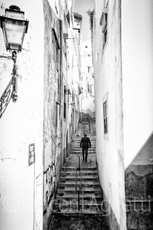 Passant montant un escalier dans une ruelle du quartier de l'Alfama à Lisbonne.
