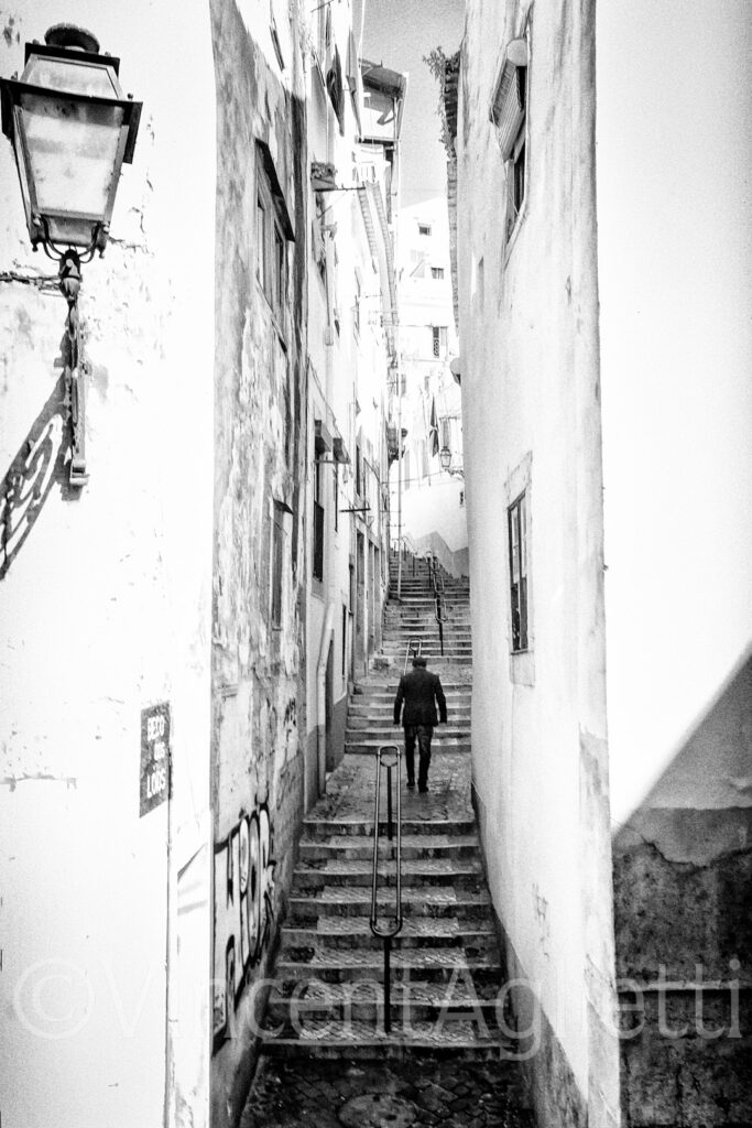 Passant montant un escalier dans une ruelle du quartier de l'Alfama à Lisbonne.