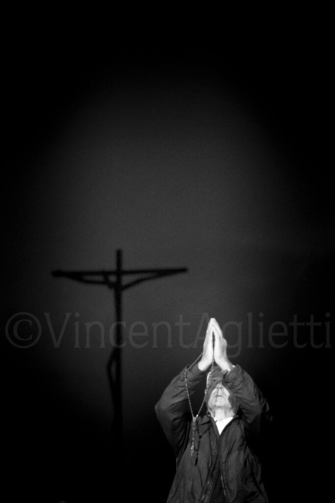 Pèlerin en prière dos au crucifix pendant le pèlerinage de Fátima au Portugal.