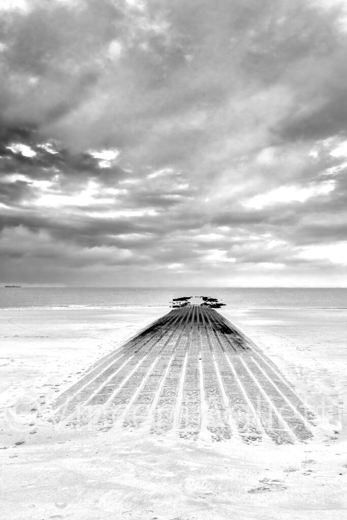 Jetée avançant dans la mer sur la plage de Knokke-le-Zoute en noir et blanc