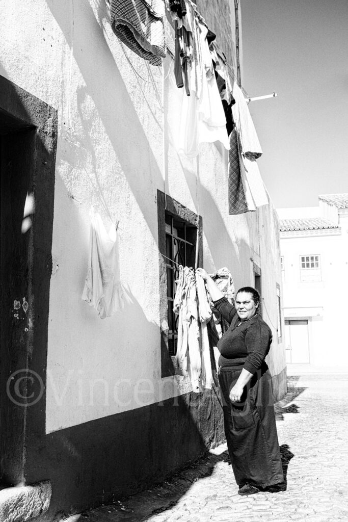 Femme étendant son linge dans une rue d'Évora au Portugal – photographie Fine Art de Vincent Aglietti