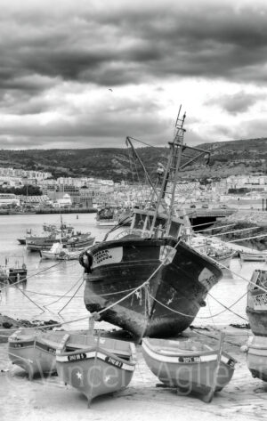 Bateaux de pêche échoués à marée basse dans le port de Sesimbra au Portugal.