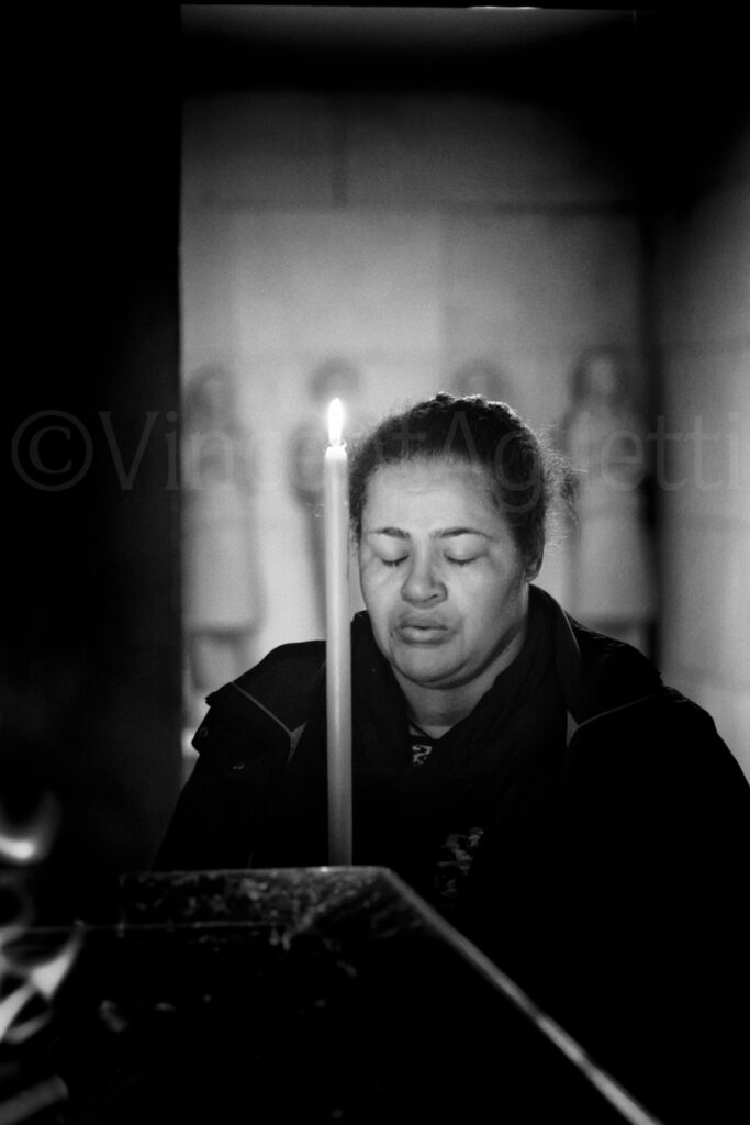 Pèlerine en prière devant un cierge dans la chapelle du sanctuaire de Fátima.