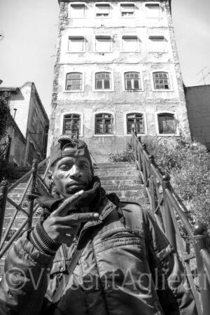 Portrait de Slim devant un immeuble abandonné dans un quartier de Lisbonne.