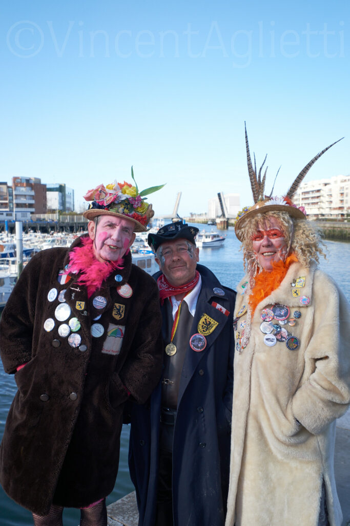 Trois carnavaleux devant le port de Dunkerque ayant guidé Vincent Aglietti vers la chapelle des dockers