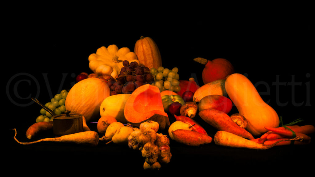 Composition de fruits et légumes d’automne photographiée sur fond noir