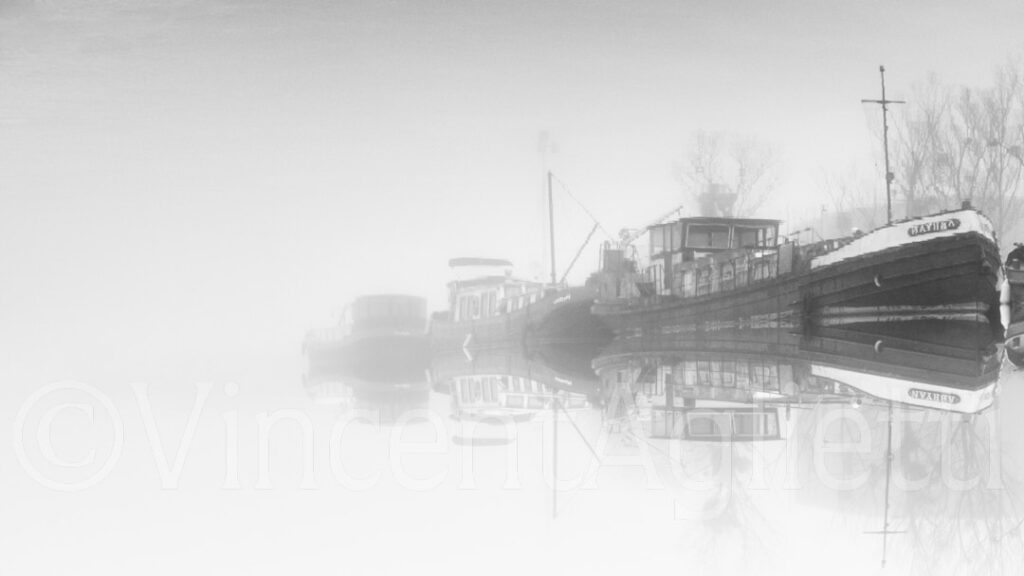 Péniches amarrées sur le canal de Bourgogne dans la brume en noir et blanc