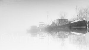 Péniches amarrées sur le canal de Bourgogne dans la brume en noir et blanc