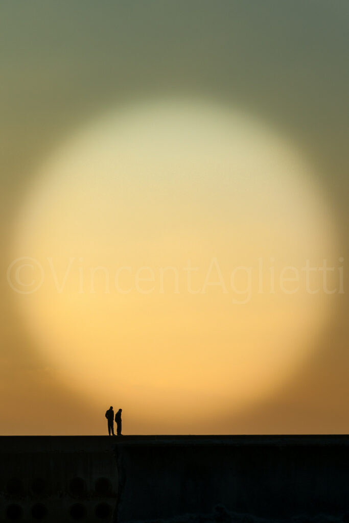 Deux silhouettes sur la jetée de Port-Diélette face au site de Flamanville