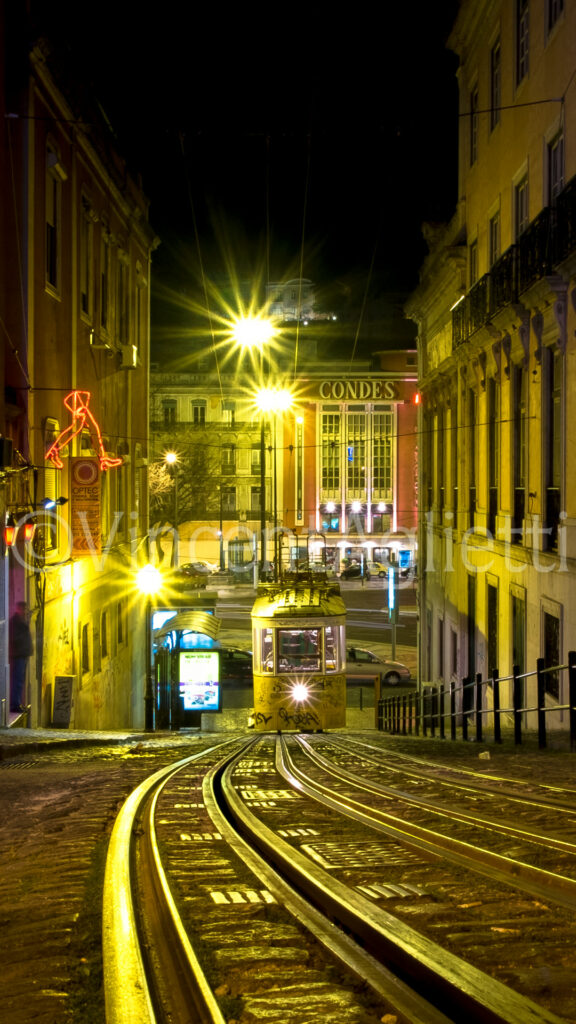 Funiculaire Elevador da Glória descendant une rue très pentue de Lisbonne la nuit