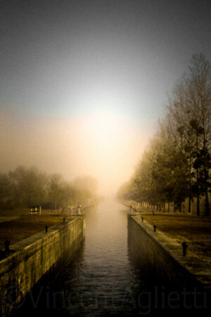 Écluse sur le canal de Bourgogne dans la brume et la lumière du matin