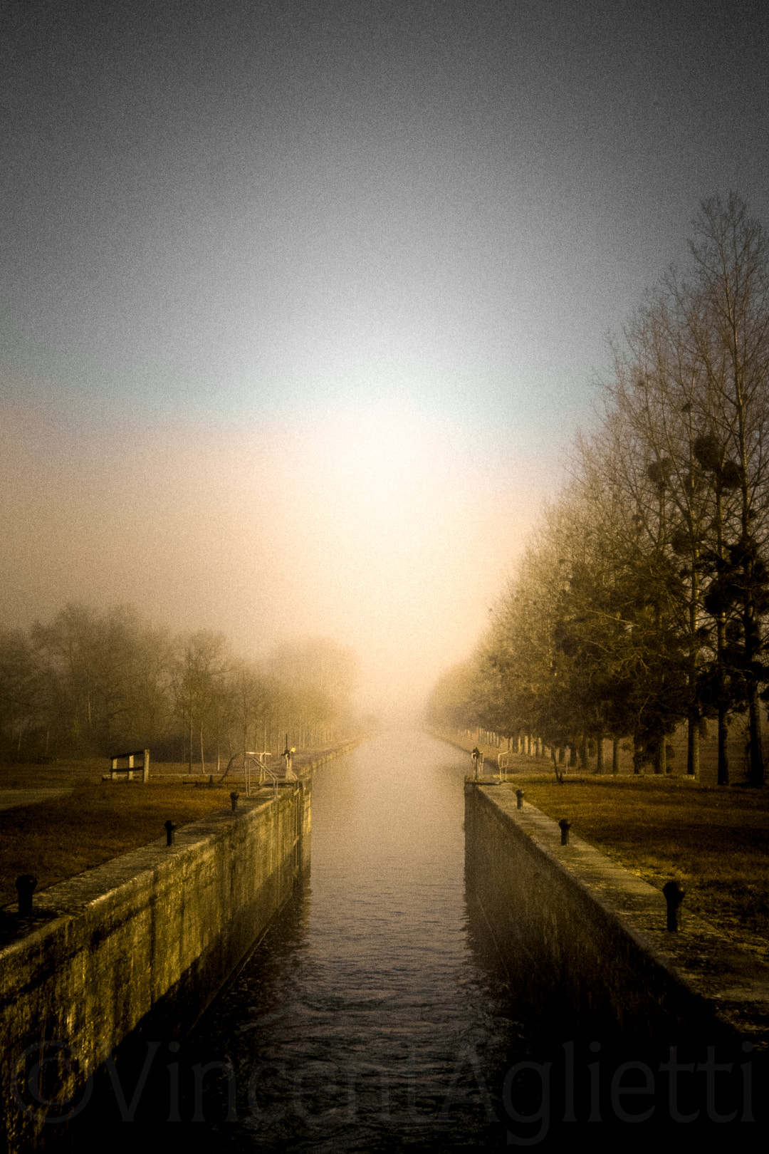 Écluse sur le canal de Bourgogne dans la brume et la lumière du matin