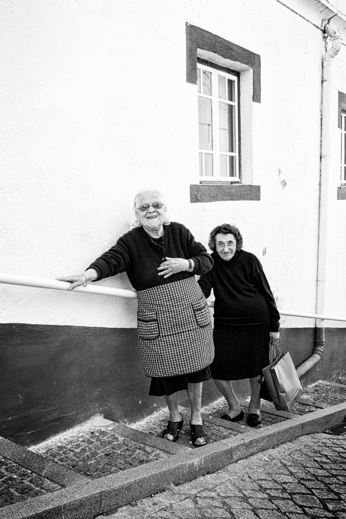 Deux femmes âgées souriantes dans une rue de Monsaraz au Portugal