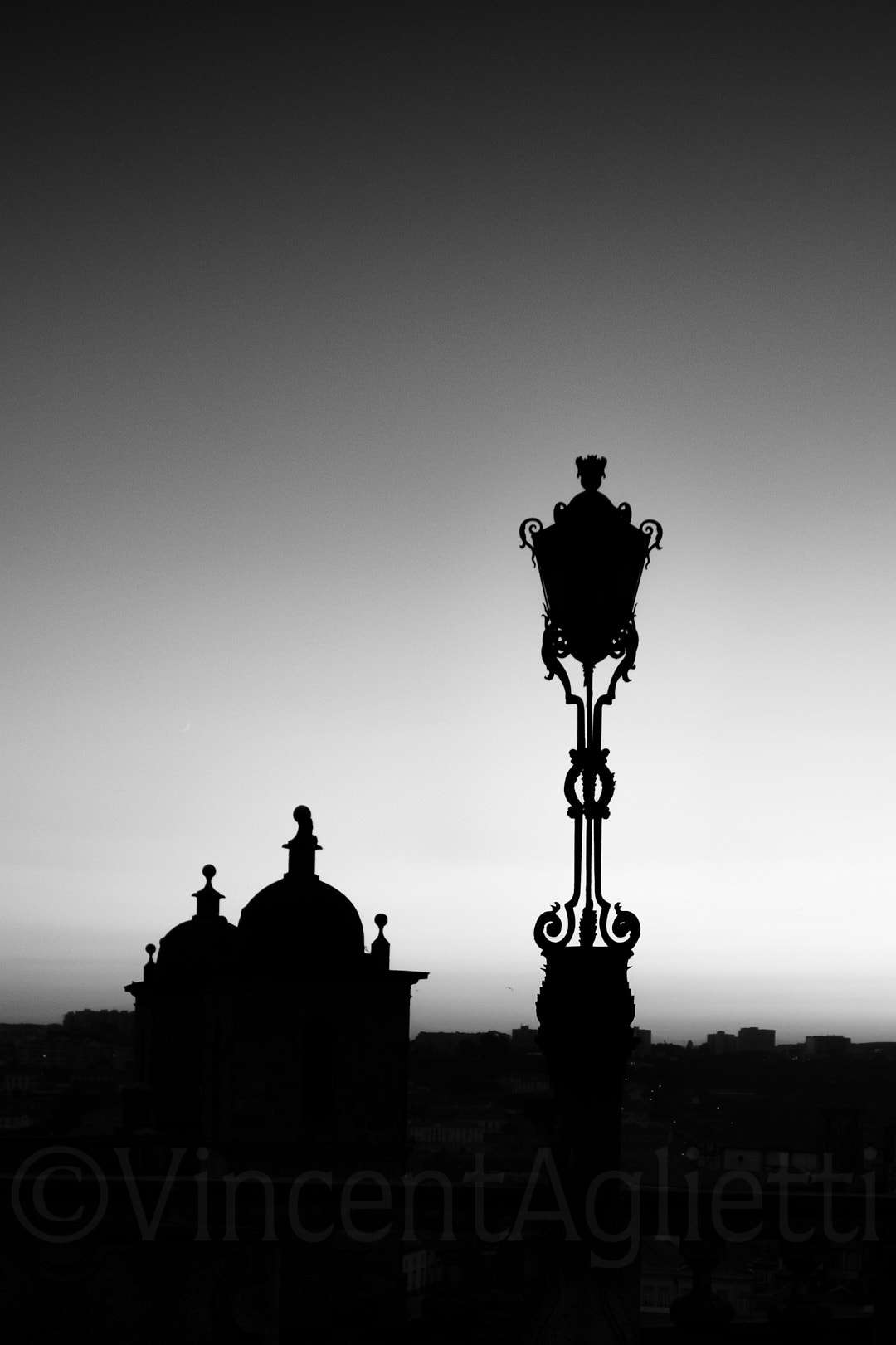 Contre-jour sur un réverbère et un dôme en fin de journée à Porto